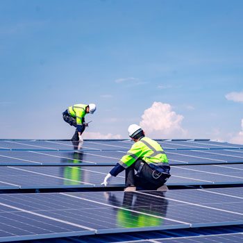 two men working on solar panels