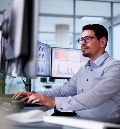 Financial engineer working at the office surrounded by monitors with data